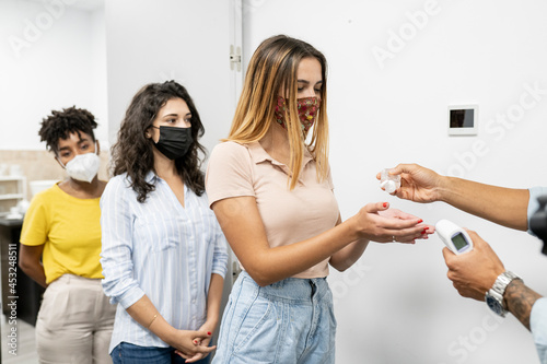 people washing hands with hydroalcoholic gel at the entrance of work in office