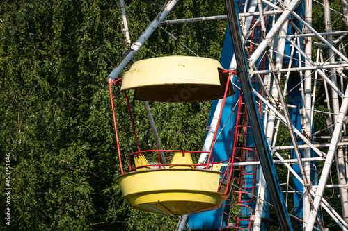 Ferris wheel booth in the park against the background of green foliage