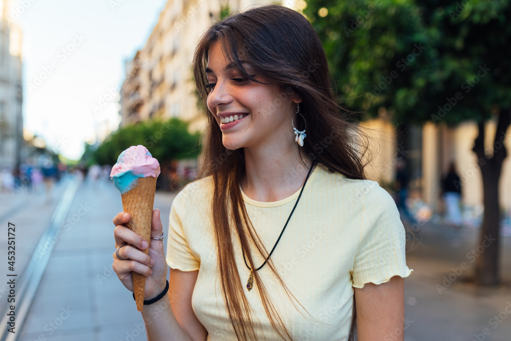 Crop happy woman with tasty ice cream cone in town Crop happy woman with tasty ice cream cone in town