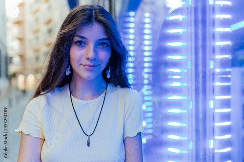 Sincere woman against neon lights on street photo