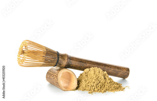 Heap of powdered matcha tea and chasen on white background