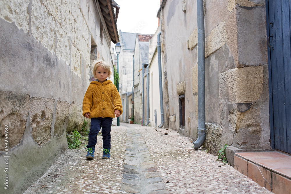 Child, boy walking in a beautiful small village street in France