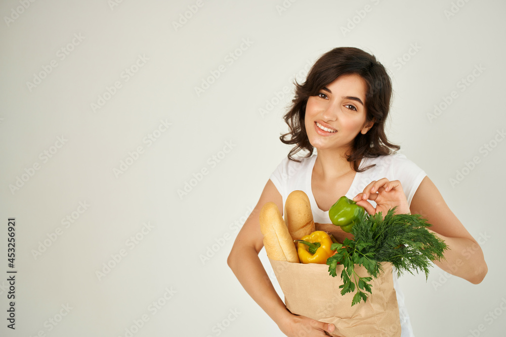 Woman in white t-shirt package with groceries healthy food delivery supermarket Woman in white t-shirt package with groceries healthy food delivery supermarket