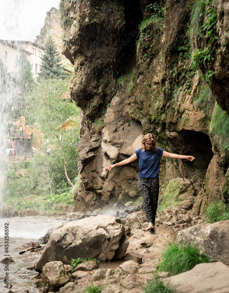Small human watching at beautiful mountain waterfall Small human watching at beautiful mountain waterfall