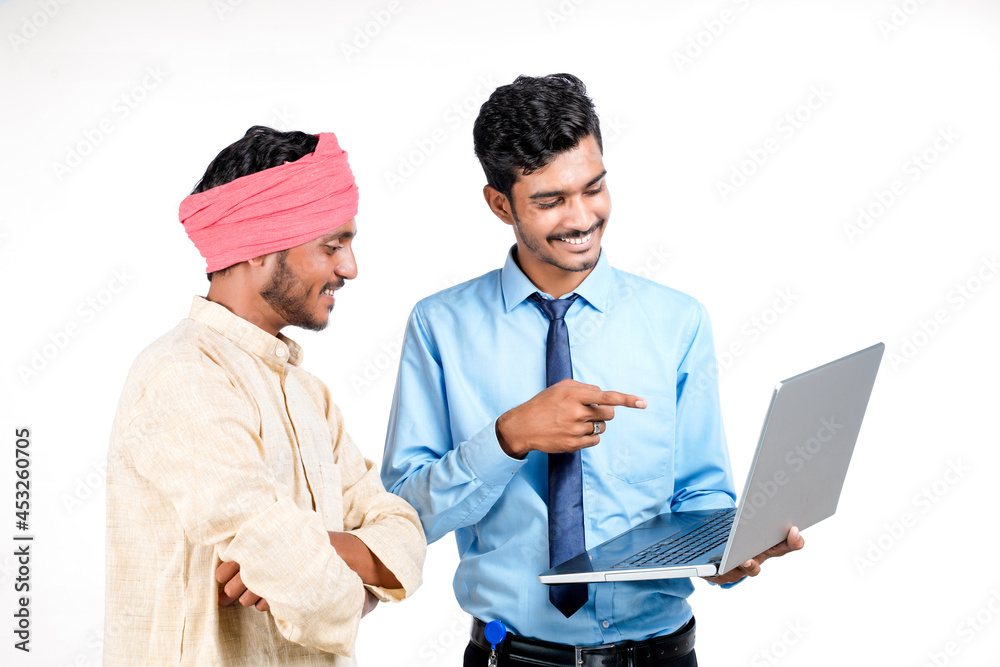 Indian bank officer or corporate government employee showing some information to farmer in laptop. Indian bank officer or corporate government employee showing some information to farmer in laptop.