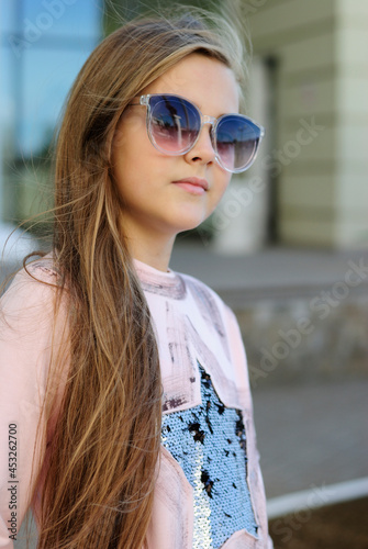 beautiful teenage girl with long hair wearing blue glasses and a plaid shirt portrait