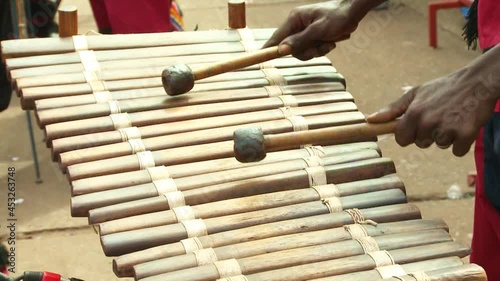 African street musician plays balafon, percussion musical instrument. Close-up of hands with sticks. Video contains vibrations. photo