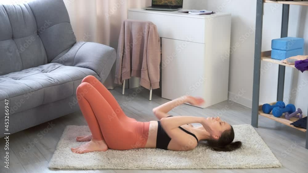 Young woman is practicing Chakrasana Wheel Pose backbend doing yoga at home, side view. Sport fitness training stretching workout yoga wellness concept. Concentration flexibility asana.
