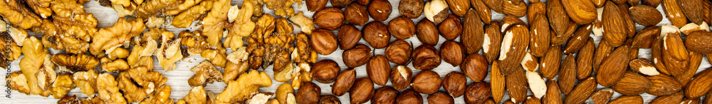 banner assortment of nuts hazelnuts, walnuts, almonds on wood table banner assortment of nuts hazelnuts, walnuts, almonds on wood table