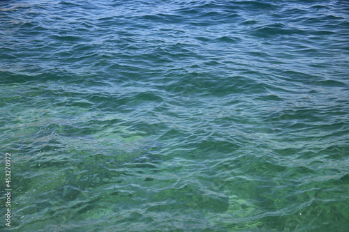 Abstract blue water background. Beautiful sparkling clear sea water. Clear sea water surface. High quality photo