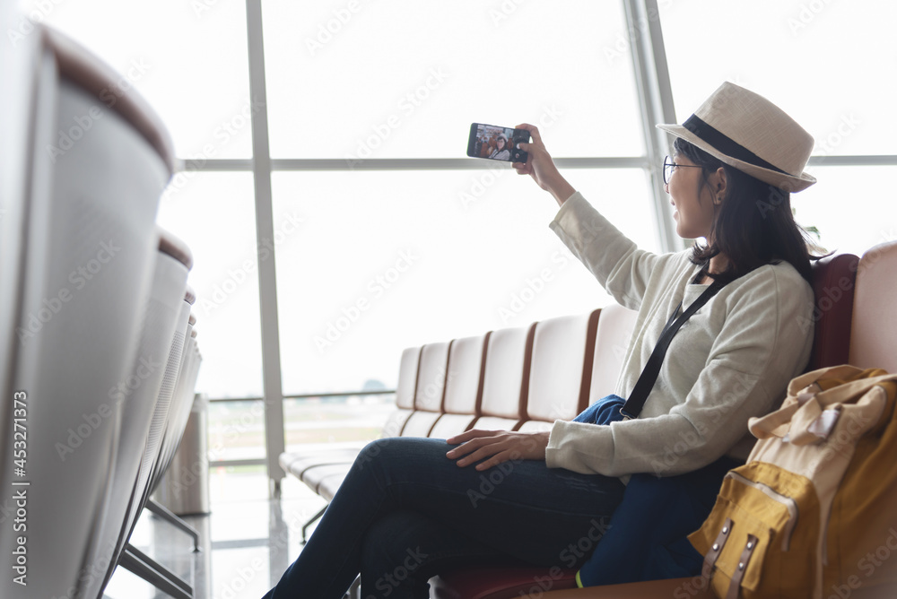 Asian woman traveler having online video call on smartphone while travel