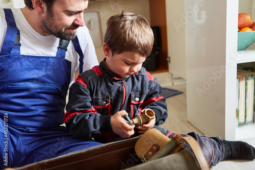 Father and son as handyman with shut-off valve © Robert Kneschke