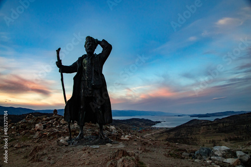 Monument to a tramp on Lake Baikal at sunset.