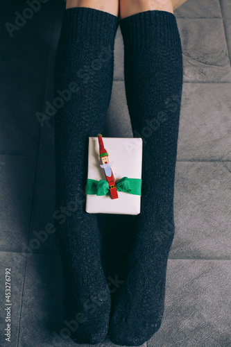 Girl Holding Holiday Gift On Her Feet