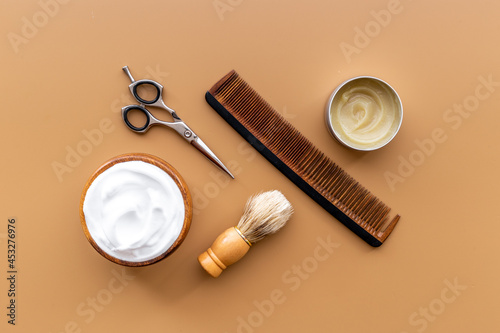 Brush foam shaver and shaving foam in wooden bowl, top view
