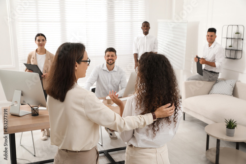 Фотография Boss introducing new employee to coworkers in office