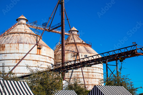 Fototapeta Closeup shot of the top of industrial buildings under the blue sky
