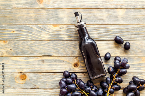 Bottle of balsamic vinegar with bunch of fresh grapes