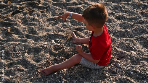 Child playing on the beach, top view 