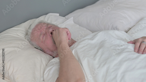 Senior Old Man with Cough Laying in Bed