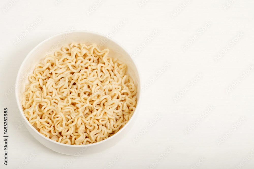 Instant noodles are placed in a white cup.