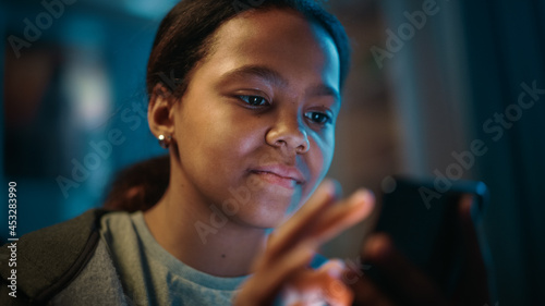 фотографія Portrait of a Teenage Multiethnic Black Girl Using a Smartphone