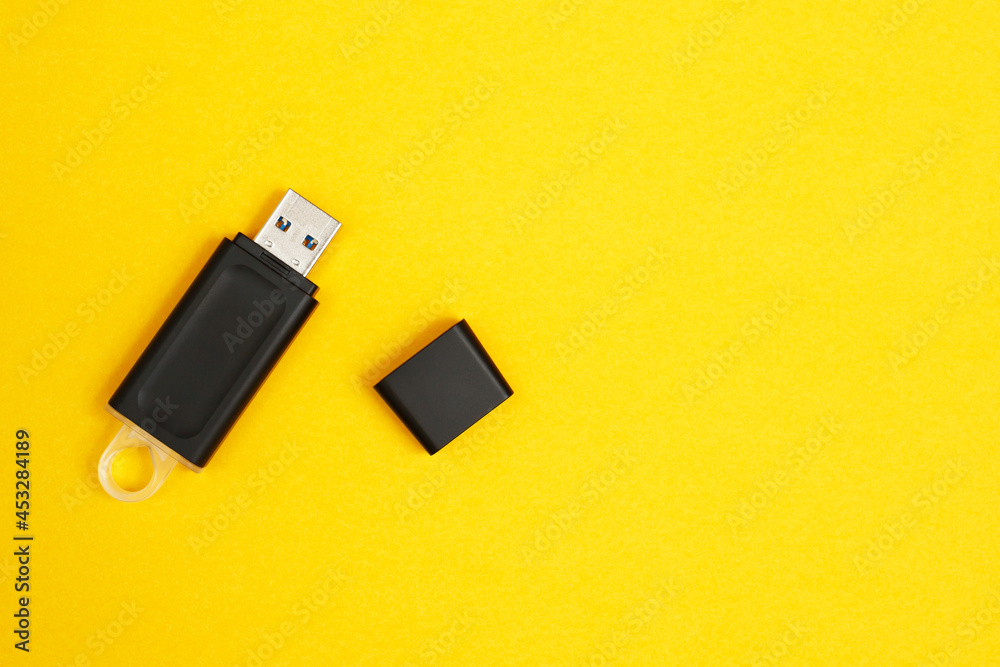 Flash drive for data storage placed on a yellow background Flash drive for data storage placed on a yellow background