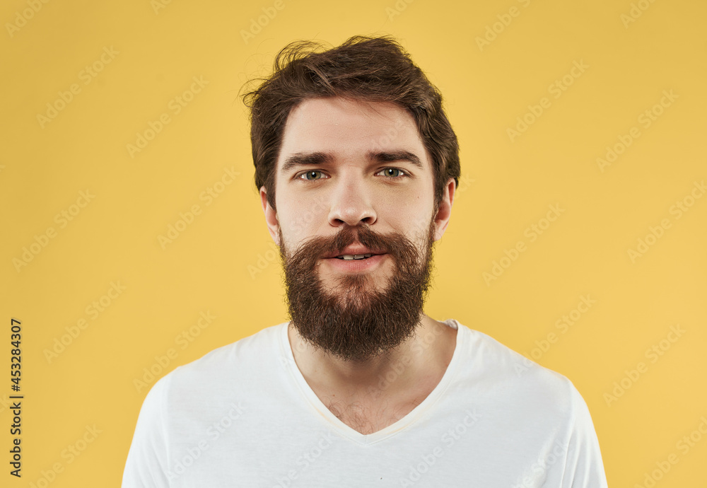handsome man in t-shirt emotions gesture with hands yellow background handsome man in t-shirt emotions gesture with hands yellow background
