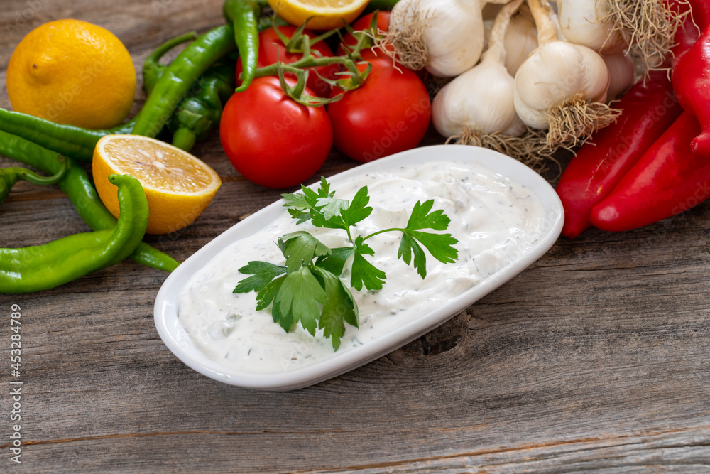 Haydari on a wooden background. Haydari is a type of yogurt made from certain herbs and spices, combined with garlic. Turkish cuisine. Close up, selective focus Haydari on a wooden background. Haydari is a type of yogurt made from certain herbs and spices, combined with garlic. Turkish cuisine. Close up, selective focus