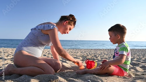 Mom plays with the child on vacation near the sea