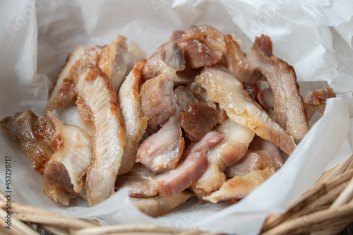 Grilled pork collar in the wooden basket.