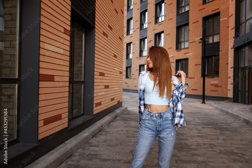attractive brunette in the city on a walk among the buildings of urban hipster
