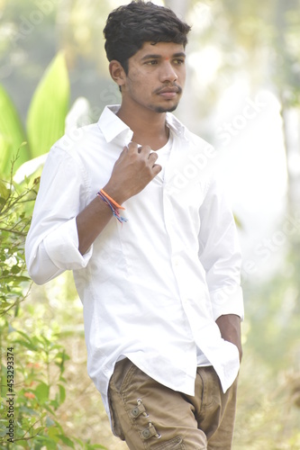 Handsome Men Posing In White T Shirt On Outdoor Nature Background. Men Holding Shirt on Hands. Indian Men  Men Model from Asia. Walking.