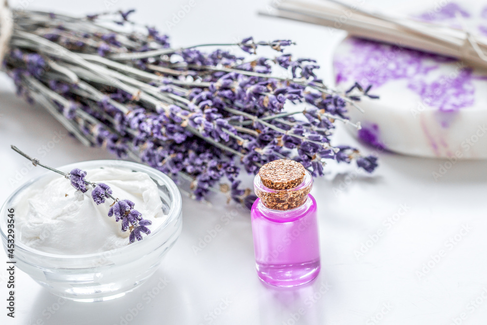 lavender herbs in body care cosmetics with oil on white table background lavender herbs in body care cosmetics with oil on white table background