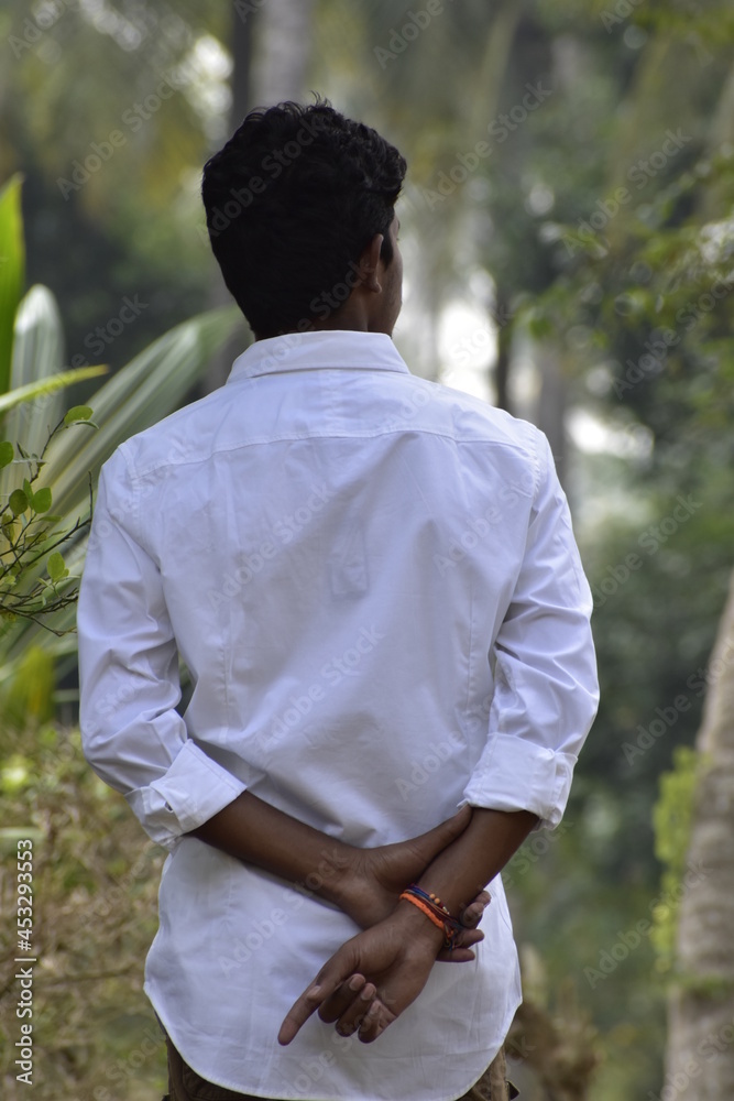 Handsome Men Posing In White T Shirt On Outdoor Nature Background. Men Holding Shirt on Hands. Indian Men Men Model from Asia. Walking. Handsome Men Posing In White T Shirt On Outdoor Nature Background. Men Holding Shirt on Hands. Indian Men Men Model from Asia. Walking.