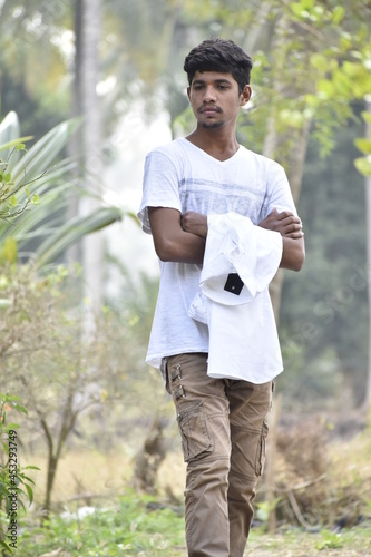 Handsome Men Posing In White T Shirt On Outdoor Nature Background. Men Holding Shirt on Hands. Indian Men  Men Model from Asia. Walking.