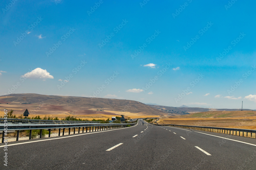 road landscape, perspective vanishing among the mountains on the horizon.