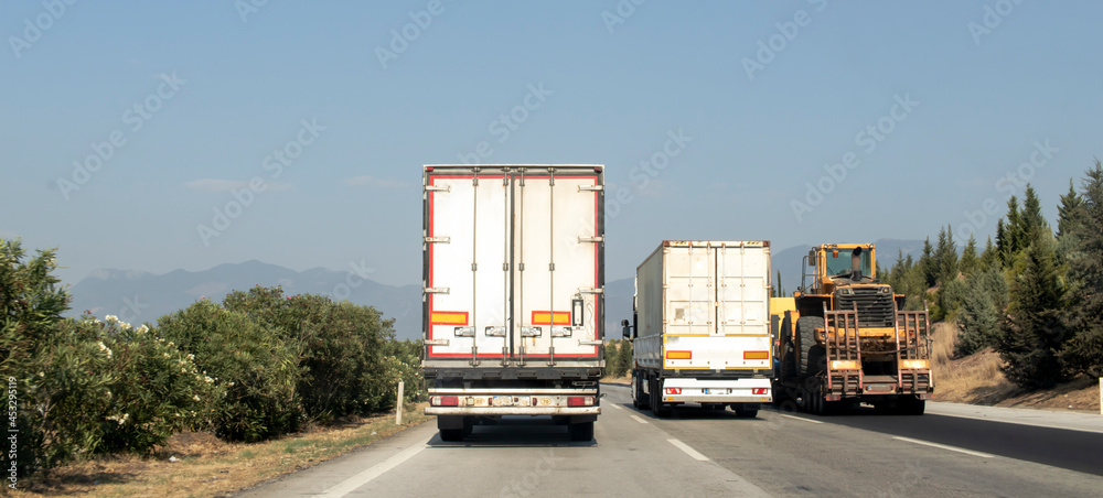 large and heavy vehicles traveling side by side on the highway. traffic generated trucks.