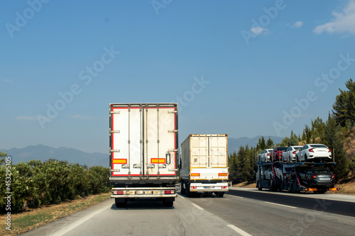 large and heavy vehicles traveling side by side on the highway. traffic generated trucks.