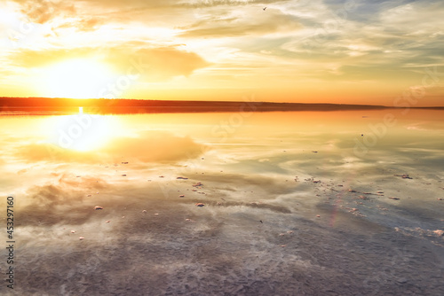 The calm surface of a salt lake with the reflection of the sky in the water at sunset. Calming landscape. Liman Kuyalnik. Ukraine. Odessa region.