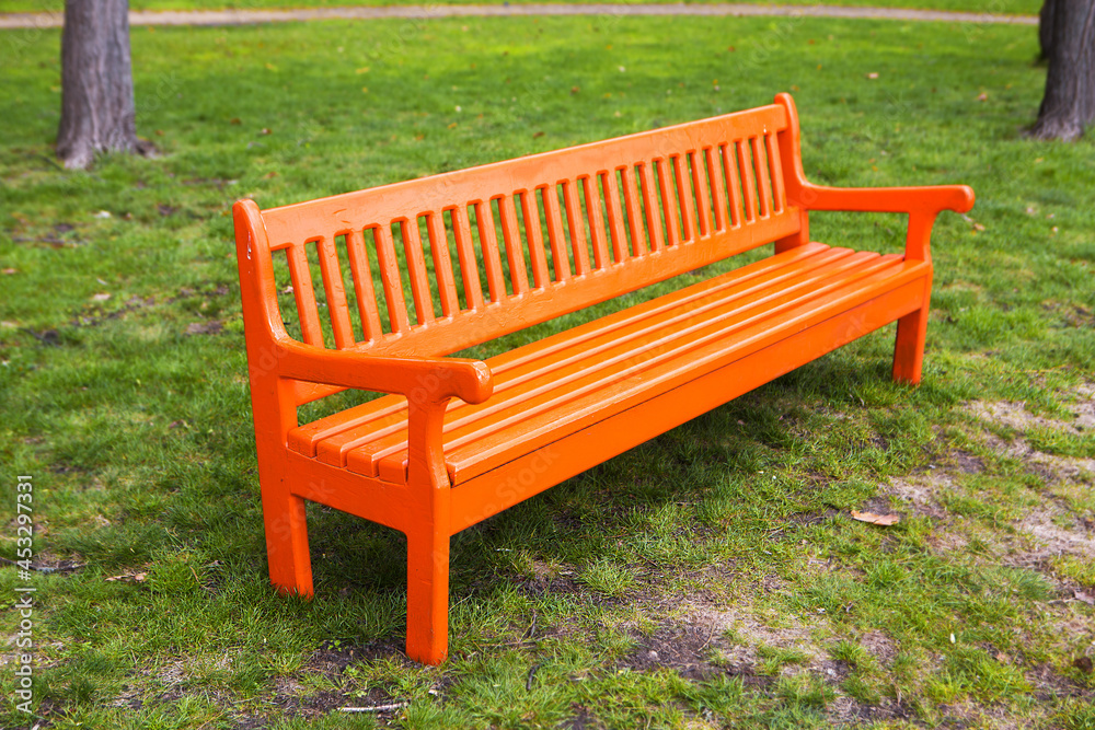 Bright orange wooden bench in the park. Bright orange wooden bench in the park.
