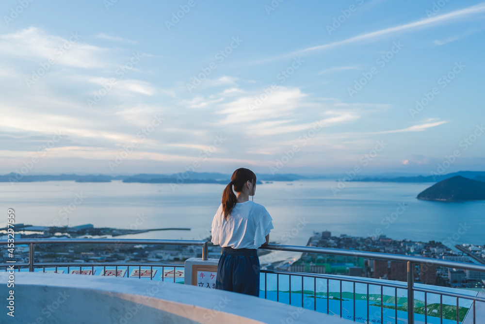 夕暮れの展望台にいる女性