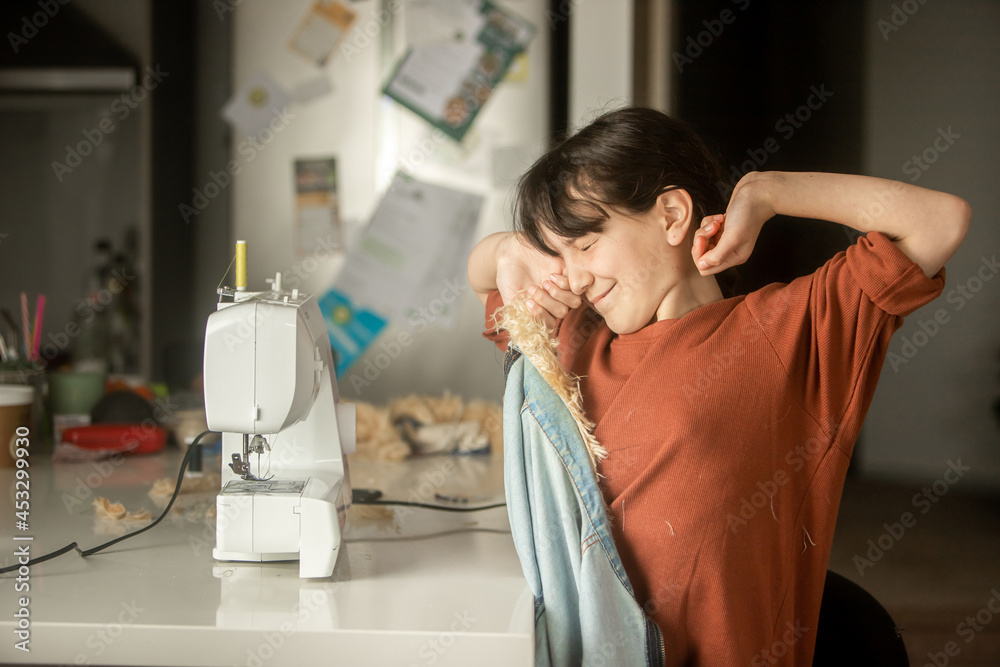 Child girl sewing at home with sewing machine Child girl sewing at home with sewing machine