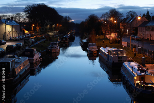 Fotografie Beautiful town riverscape with boats in the evening