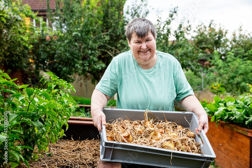 mentally handicapped woman holding a basket full of fresh onions