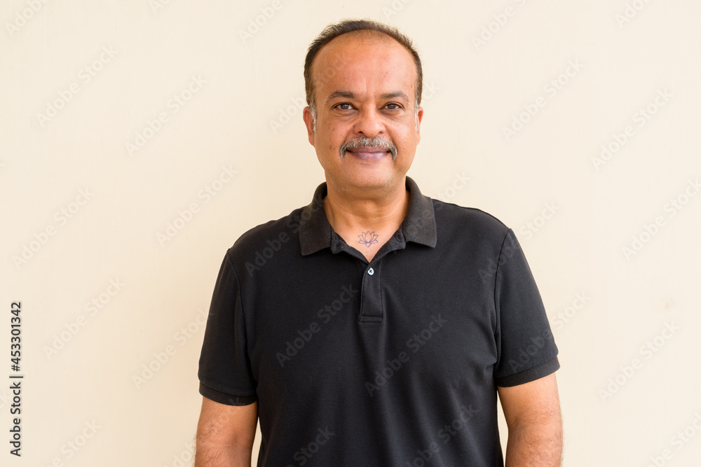Portrait of happy Indian man with mustache against plain wall Portrait of happy Indian man with mustache against plain wall