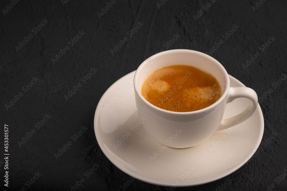 Espresso in a white cup on a dark background