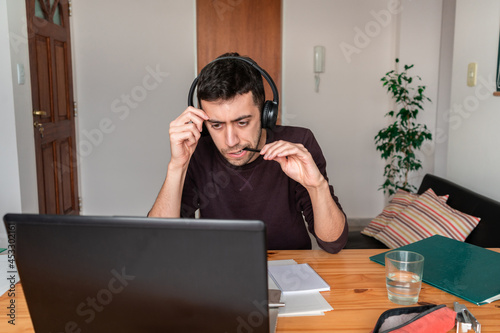 Fotografie Nervous student focused on the online class and chewing on his pen