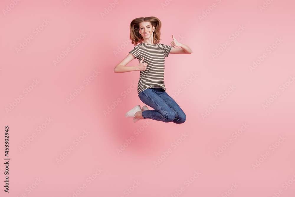 Full body portrait of young woman happy positive smile show thumb-up like fine choice advert jump up isolated over pink color background