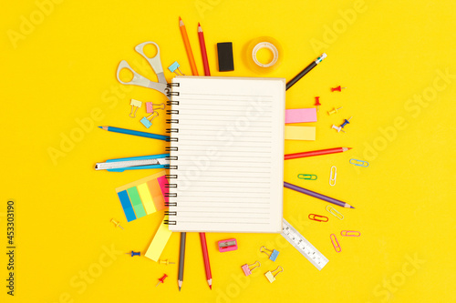 Concept of education top view notebooks and accessories stationery studying in the library at school yellow background